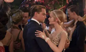 Para Gatsby'ego, taniec z Daisy to chwila magii. Ona w błyszczącej sukni, on w eleganckim garniturze, otoczeni gośćmi na przyjęciu.