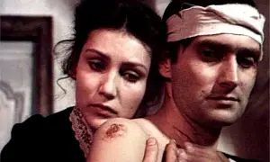Kobieta troskliwie obejmuje rannego mężczyznę z opaską na głowie. Scena z jednego z filmów z Olgierdem Łukaszewiczem.