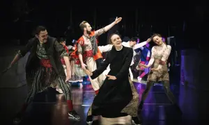 Aktorzy Narodowego Starego Teatru w Krakowie w barwnych strojach na scenie.
