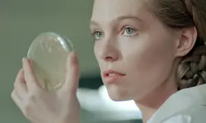 Młoda kobieta z warkoczem ogląda szalkę Petriego. Scena z filmów Małgorzaty Braunek.