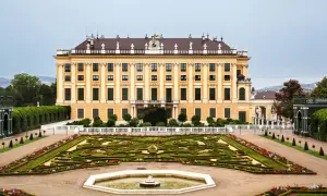 Pałac Schönbrunn w stylu rokoko, z ogrodem w geometryczne wzory i fontanną.