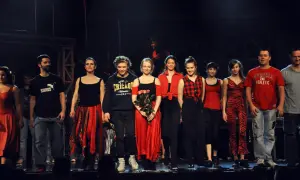 Aktorzy teatru buffo na scenie, w kolorowych strojach, pozdrawiają publiczność.