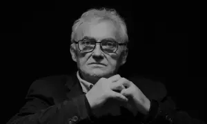 Portret Janusza Kondratiuka, reżysera znanych filmów, z dłońmi złożonymi na piersi.