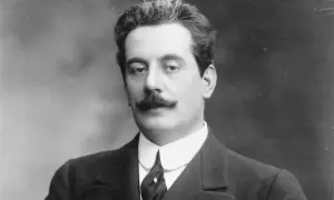 Giacomo Puccini, kompozytor słynnych oper, w eleganckim garniturze. Jego muzyka wciąż porusza serca słuchaczy.