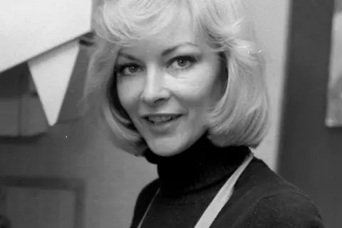 Barbara Brylska, ikona polskiego kina, w uśmiechniętej pozie. Jej charakterystyczna fryzura i spojrzenie przywodzą na myśl niezapomniane role w jej filmach.