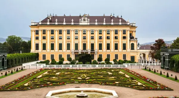 Pałac Schönbrunn w stylu rokoko, z ogrodem w geometryczne wzory i fontanną.