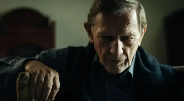 Jan Englert w filmach, zamyślony, z dłonią na lasce.