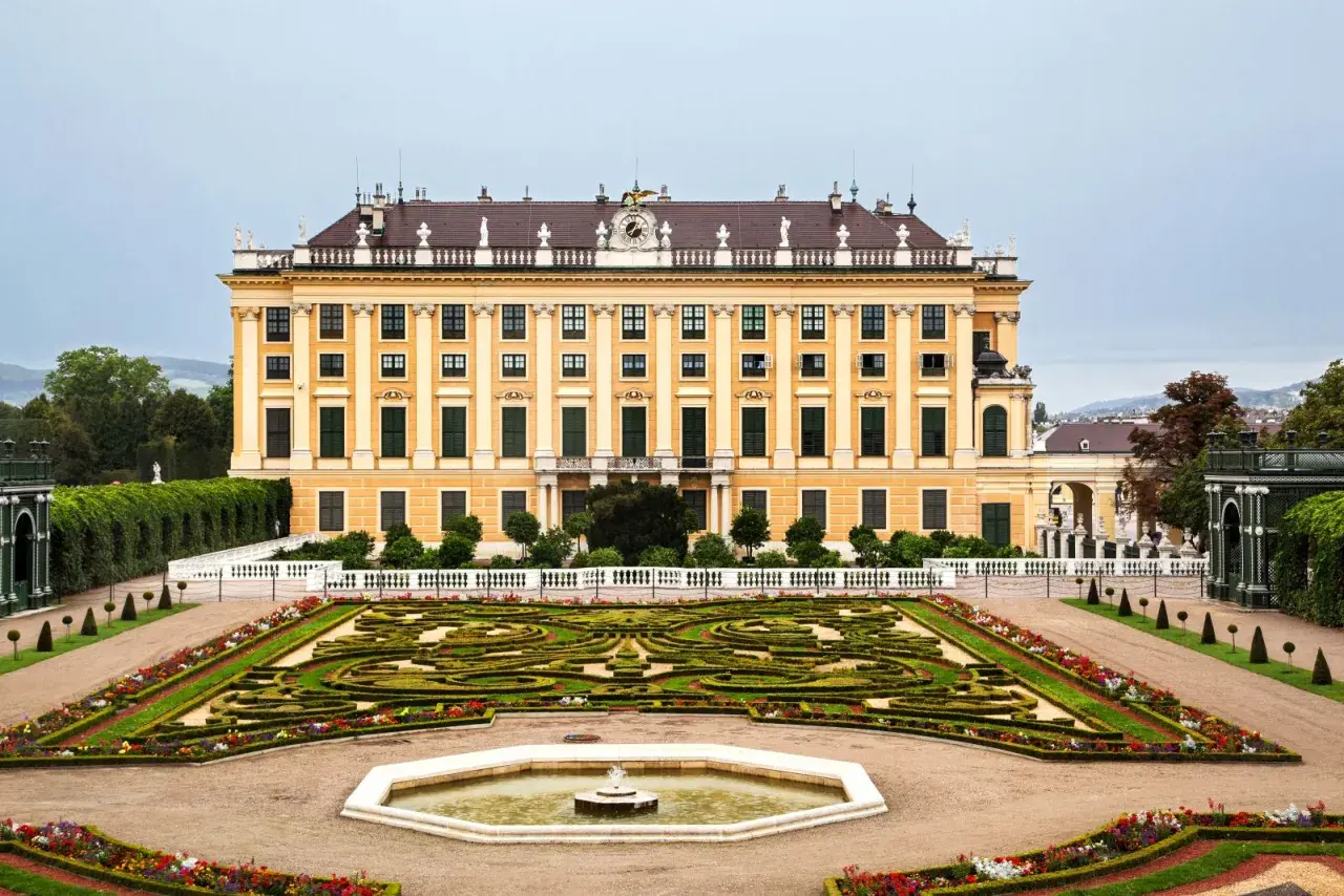 Pałac Schönbrunn w stylu rokoko, z ogrodem w geometryczne wzory i fontanną.