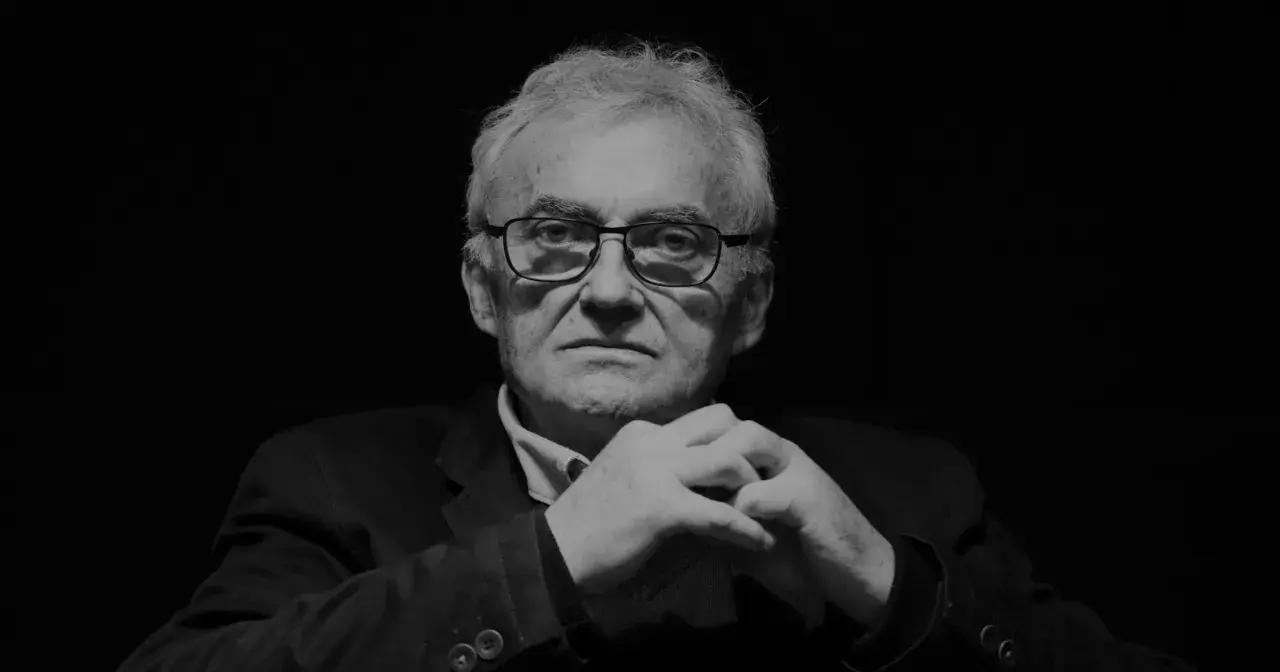 Portret Janusza Kondratiuka, reżysera znanych filmów, z dłońmi złożonymi na piersi.