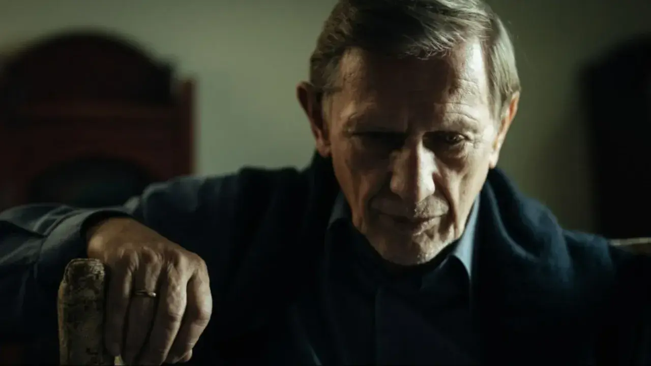 Jan Englert w filmach, zamyślony, z dłonią na lasce.