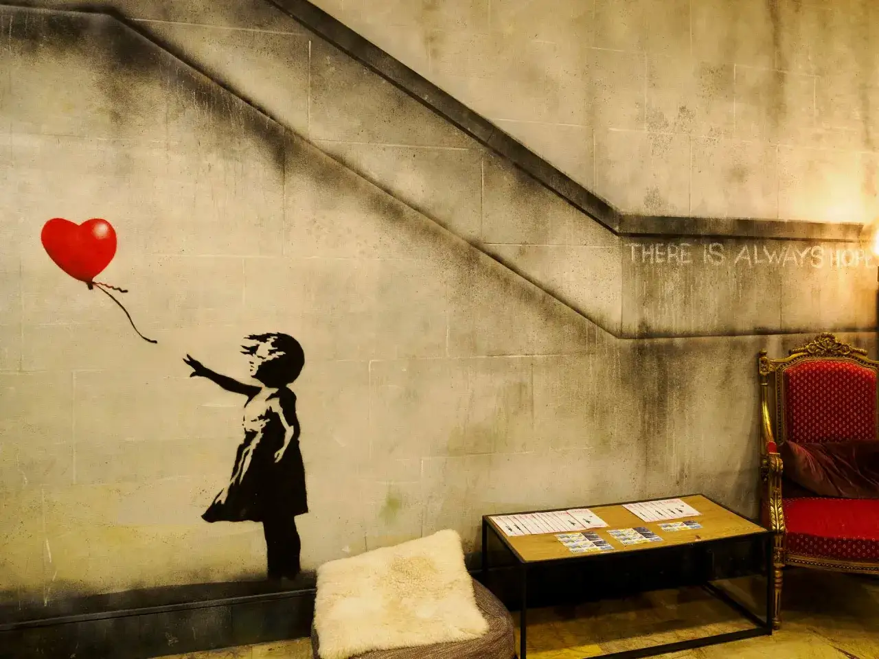 Dziecko z czerwonym balonem w kształcie serca, dzieło Banksy'ego, symbolizuje nadzieję.