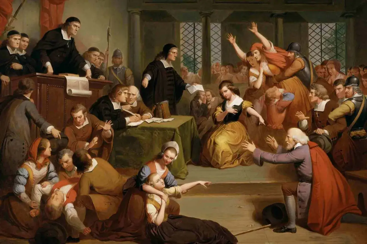 Scena sądowa, gdzie oskarżony John Proctor broni się przed zarzutami, podczas gdy świadkowie wskazują palcami i krzyczą.