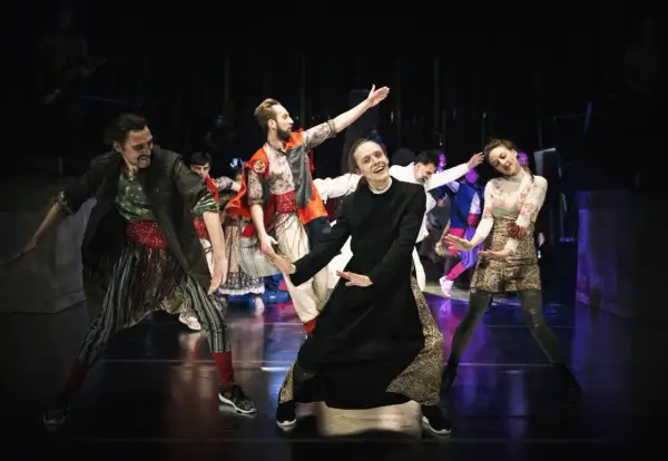 Aktorzy Narodowego Starego Teatru w Krakowie w barwnych strojach na scenie.