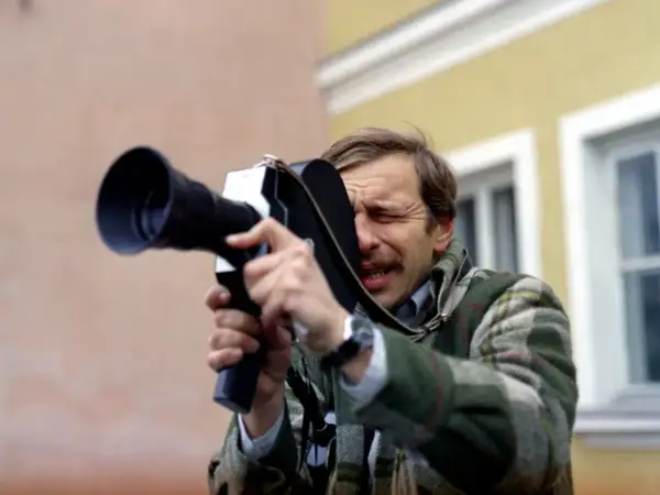 Jerzy Stuhr w filmie Kieślowskiego, z kamerą w ręku, skupiony na kadrze.