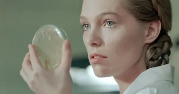 Młoda kobieta z warkoczem ogląda szalkę Petriego. Scena z filmów Małgorzaty Braunek.