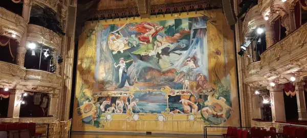 Teatr mój widzę ogromny, z bogato zdobionymi lożami i wielkim, barwnym malowidłem na scenie, przedstawiającym sceny z mitologii.