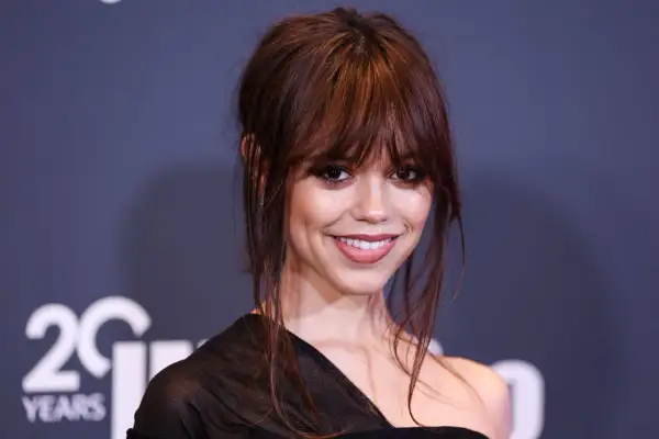 Jenna Ortega, aktorka znana z roli Wednesday Addams, uśmiecha się do obiektywu.