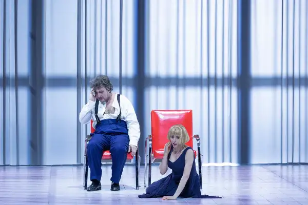 Mężczyzna i kobieta na scenie, w dramatycznych pozach, podczas jednego z Warlikowski spektakli.