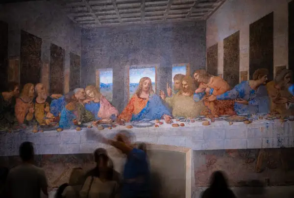Leonardo da Vinci's "Ostatnia Wieczerza" - Jezus pośród apostołów przy stole, w tle krajobraz.