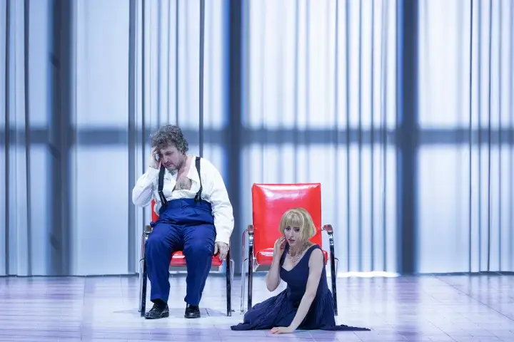 Mężczyzna i kobieta na scenie, w dramatycznych pozach, podczas jednego z Warlikowski spektakli.