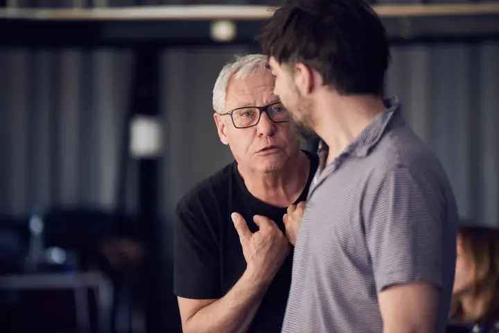 Dyrektor Teatru Roma, starszy mężczyzna w okularach, rozmawia z młodszym kolegą.
